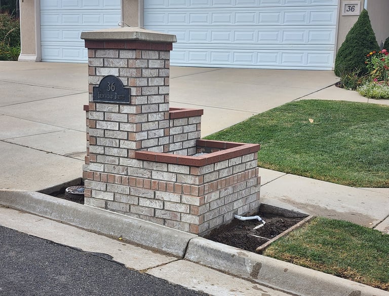 Brick pillar with attached planter box and address plate