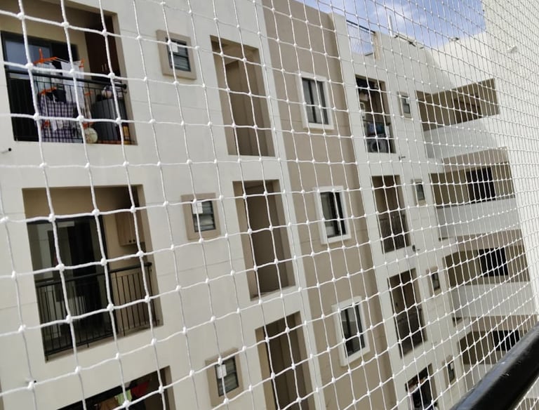 Technician installing a safety net on a high-rise balcony in Bengaluru.
