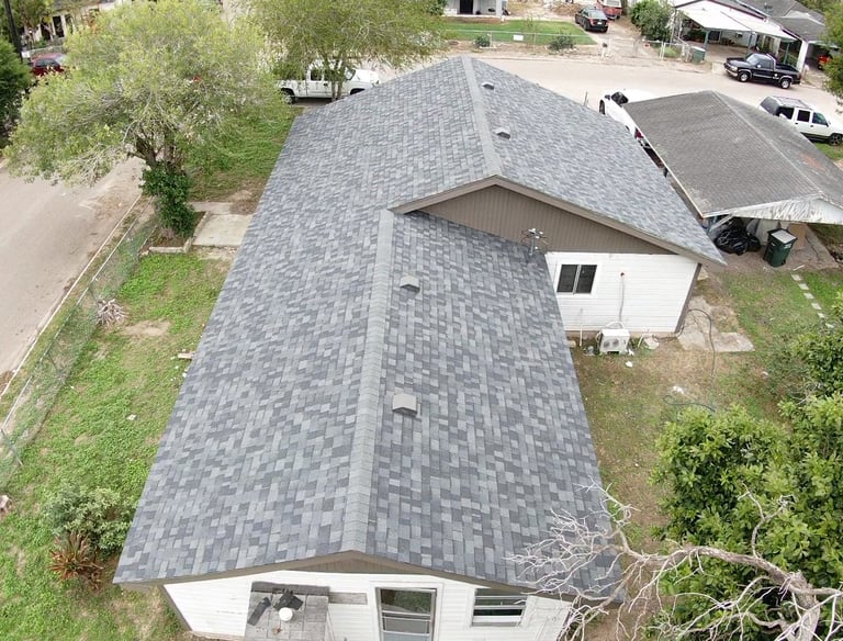 Aerial view of a residential home featuring a newly installed gray asphalt shingle roof.
