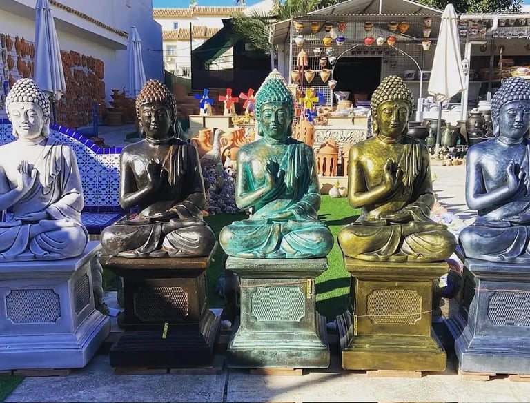 A row of colorful ceramic Buddha statues for sale at an outdoor garden decor market.