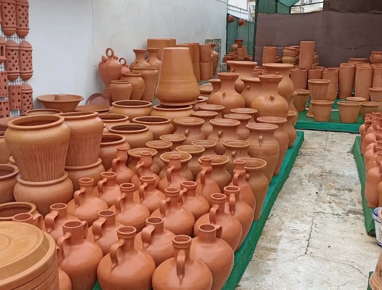 A large display of traditional terracotta pottery and handmade ceramic clay pots for sale.
