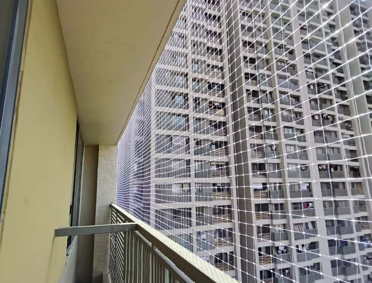 Wide shot of a residential balcony fully secured with sturdy pigeon nets.