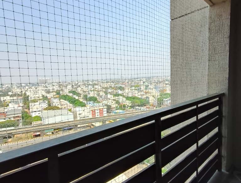 Close-up of tightly woven balcony safety net with clear outdoor background.