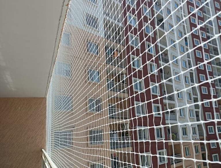 Wide view of a modern apartment balcony fully protected with a neatly fitted pigeon net.