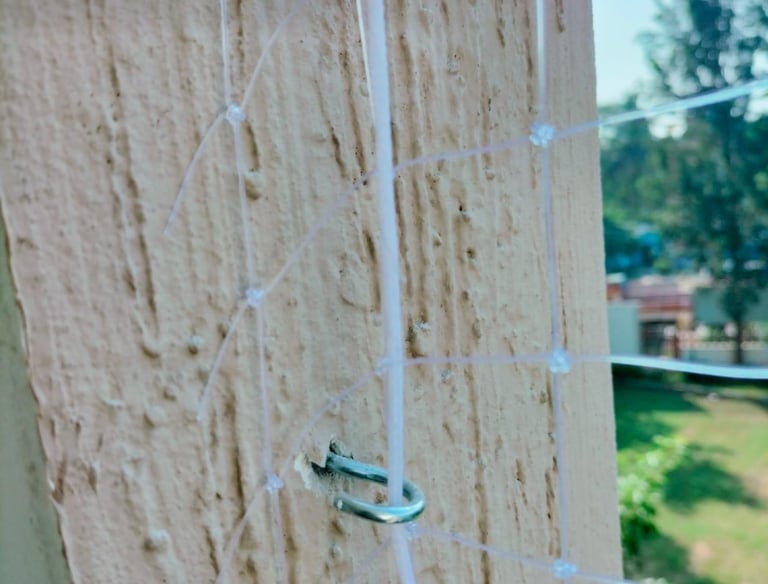 Technician carefully installing strong safety net on an apartment balcony in Sholinganallur.