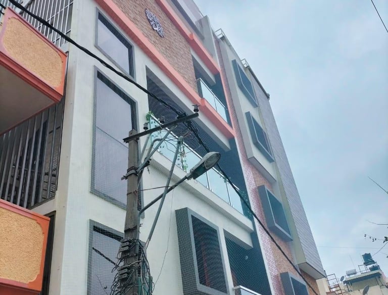 Technician carefully installing anti-pigeon netting on a window frame.