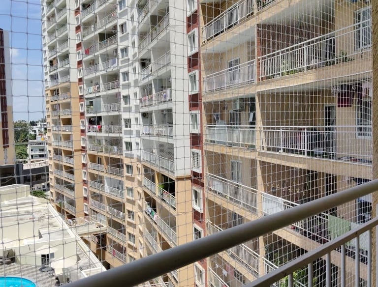Close-up of a sturdy balcony pigeon net tightly fitted to a railing in a residential area.