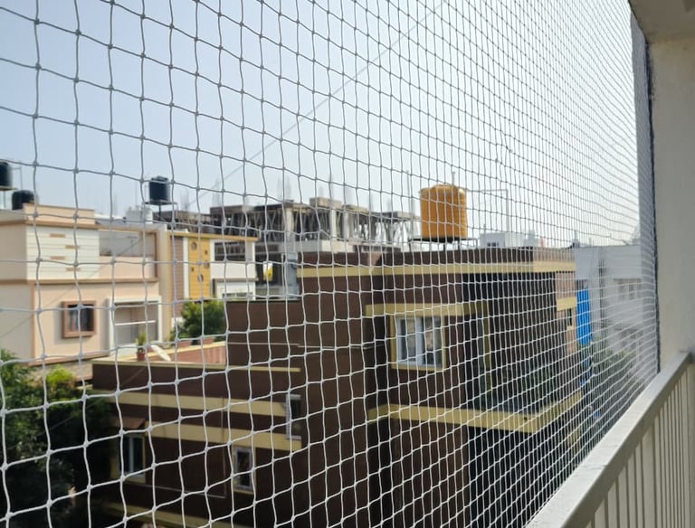 Technician carefully measuring a balcony for a custom safety net installation.