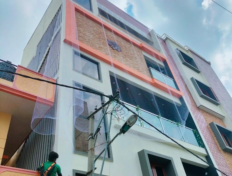 Close-up of a sturdy anti-pigeon net installed on a residential balcony in Nungambakkam.