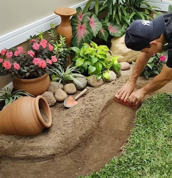 a man is kneeling down in a garden
