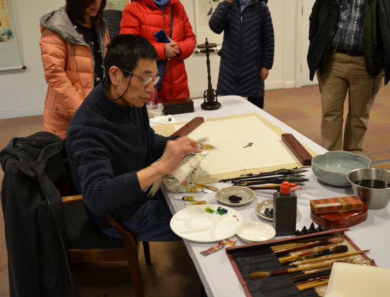 an artist sitting painting at a workshop