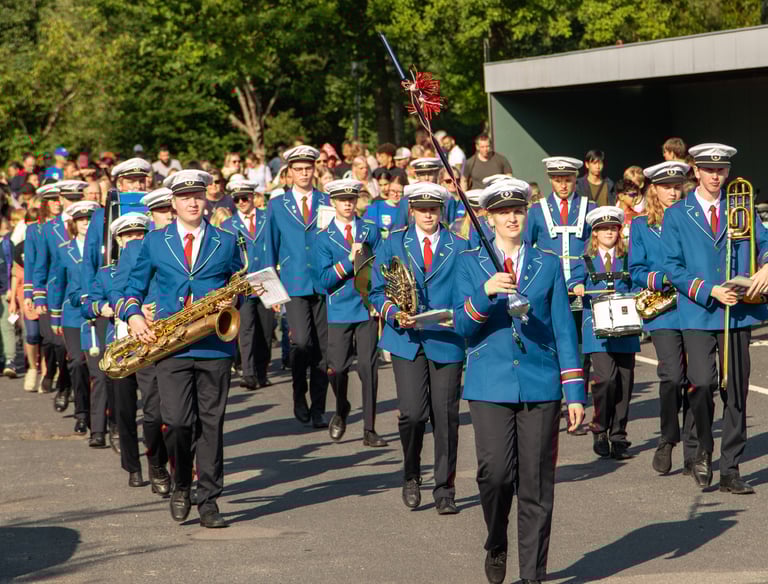 a bandleader in blue uniforms marching the band