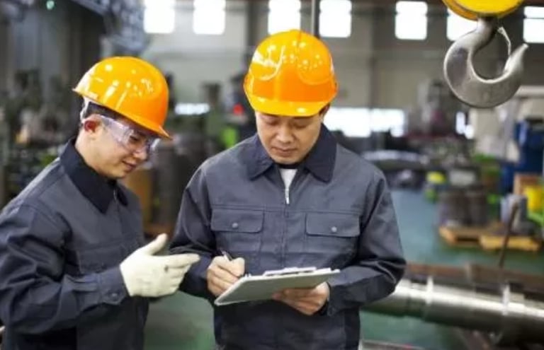 two men in hard hats and hard hats are standing in hongmeng tractors factory