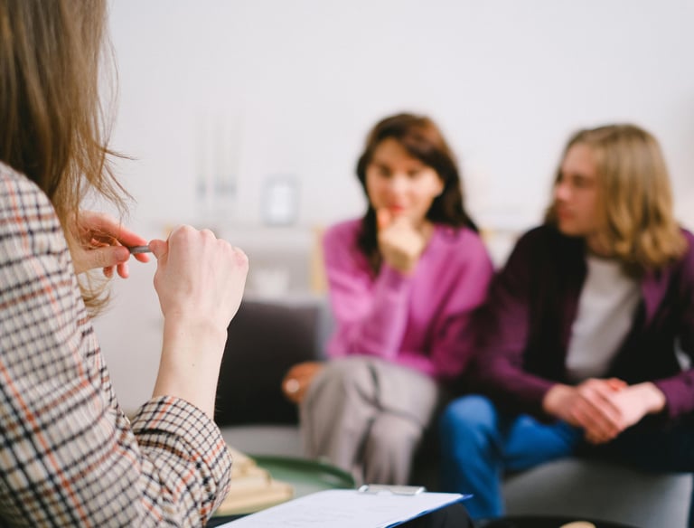 a woman in a plaid shirt is sitting in a group of people