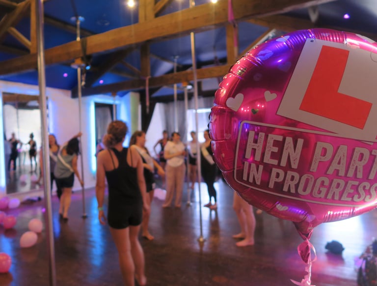 Image of a hen party balloon in the foreground with a group of people using the Sxefit facilities 