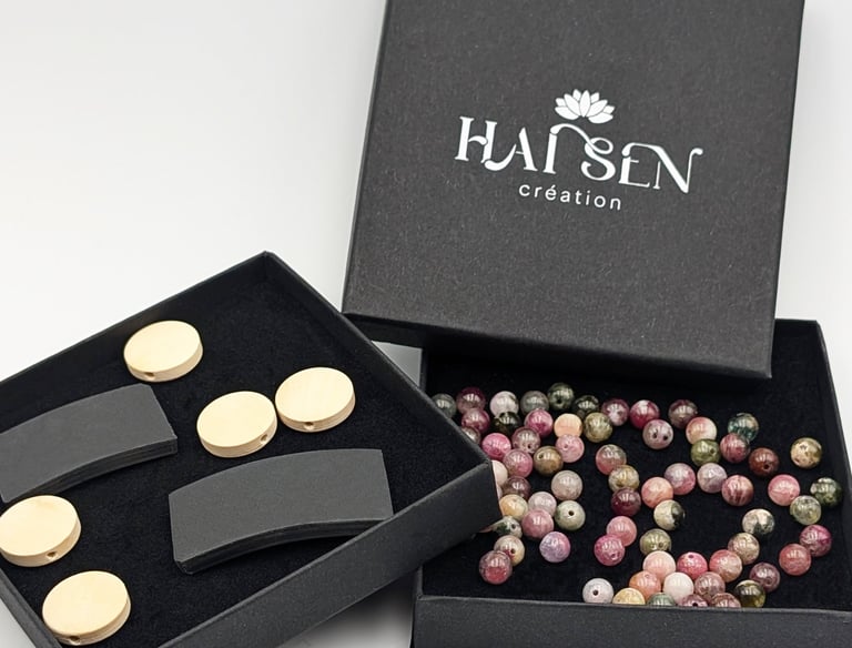 Boîte Hái Sen Création avec perle colorée, cabochon non gravé et plaque noire sans incrustation.