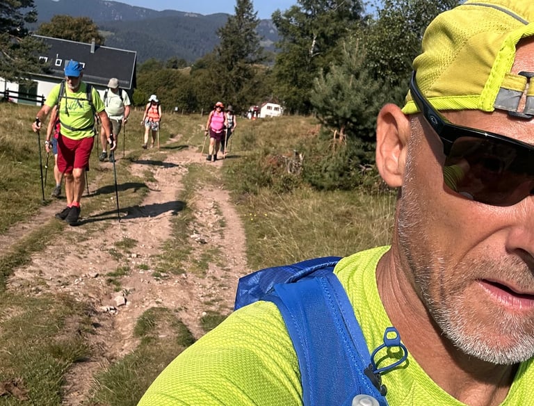 Groupe de personnes pratiquant le Nordic Walking sur un sentier forestier, utilisant des bâtons spécifiques pour optimiser le