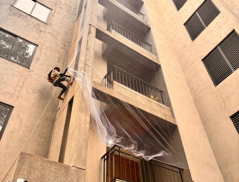 Wide view of a residential building fully covered with pigeon nets for safety.