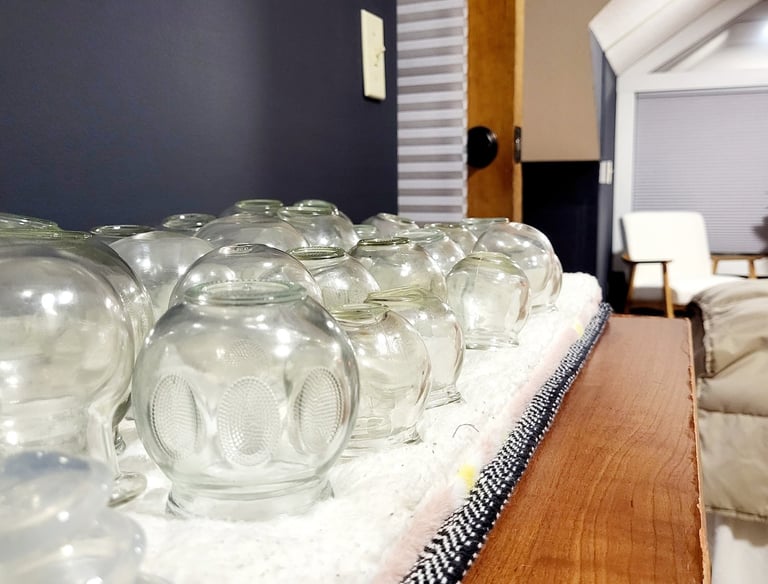 Glass fire cups used for cupping therapy during a customized massage session.