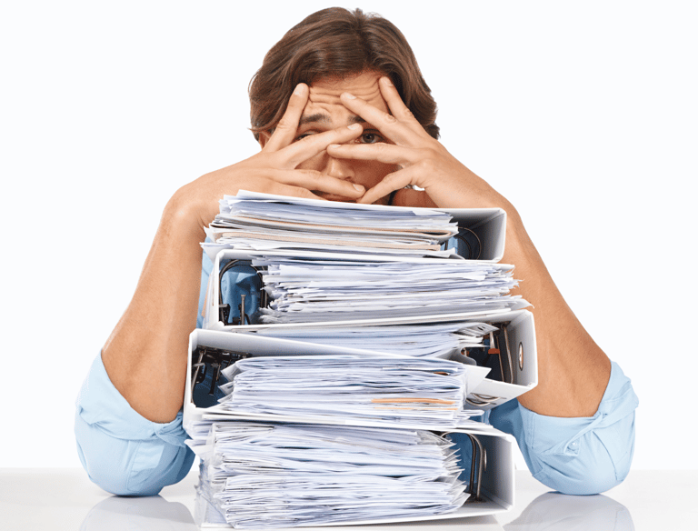 Stressed businessman overwhelmed with piles of paperwork, highlighting the need for an efficient IT solution to streamline op