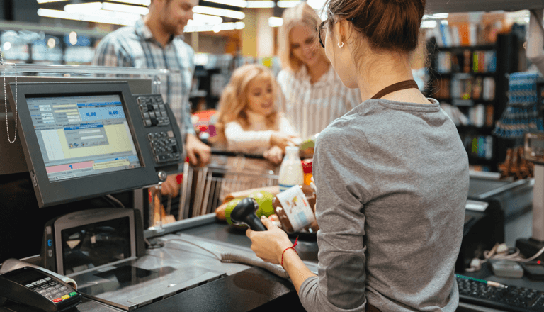 a woman is standing in front of a cash register
