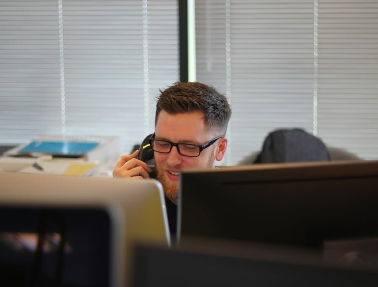 Team member is talking on the phone at the desk