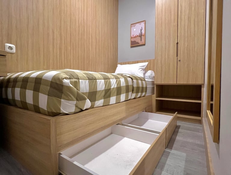 Kamar kos eksklusif dengan single bed, meja belajar, lemari kayu, dan cermin full body di Kos Si Bos