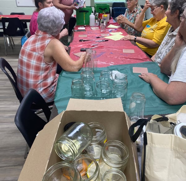 women learning the crafts that will be done during camp