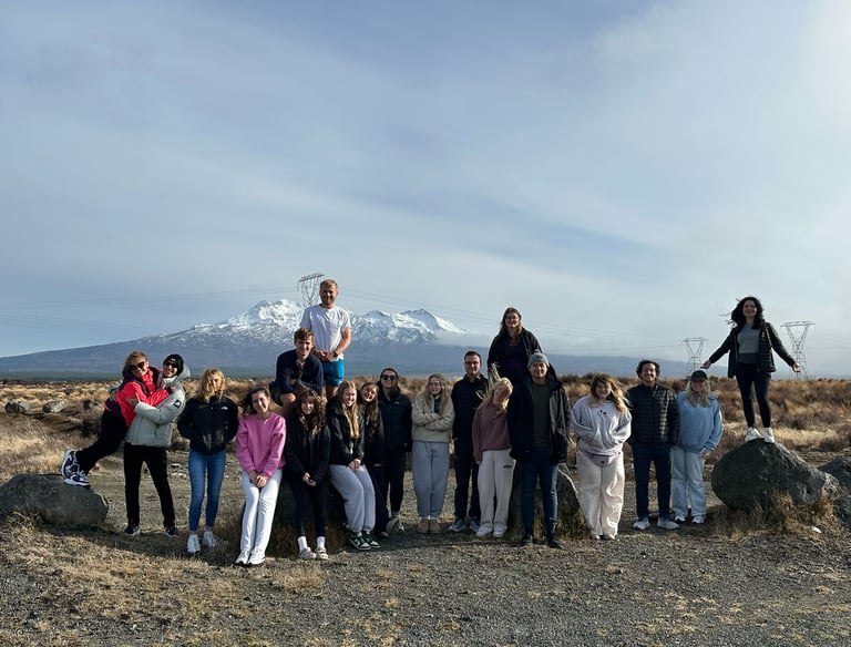 a tour group standing in front of a mountain in the north island of new zealand