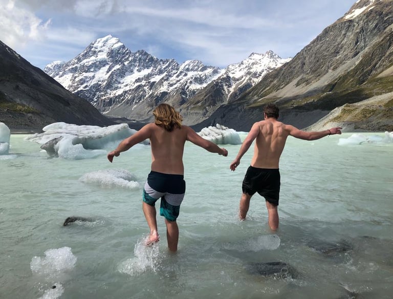 two travellers enjoying a swim in the hooker glacier, under mount cook 