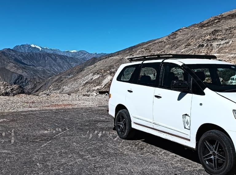 a white van parked in front of a mountain