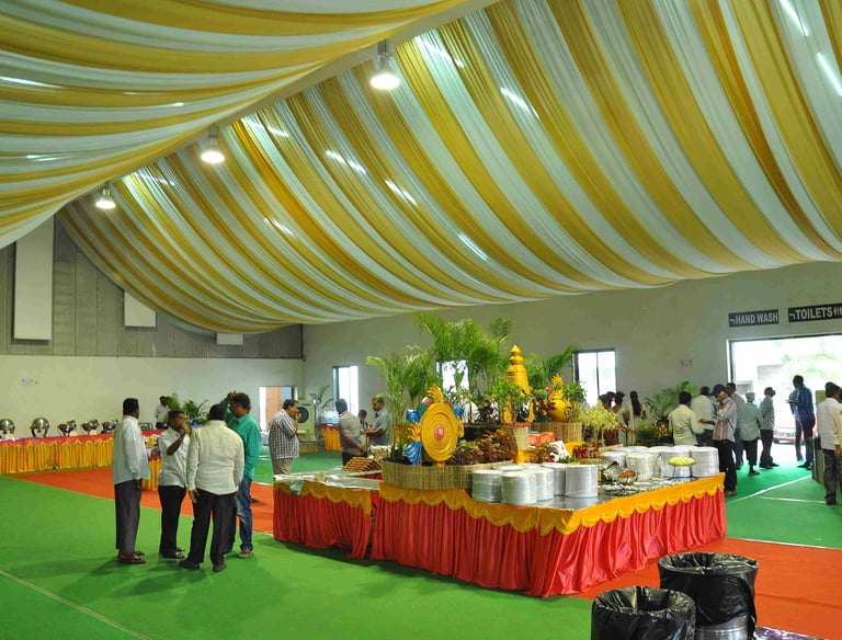 a large room with a lot of people standing around a table