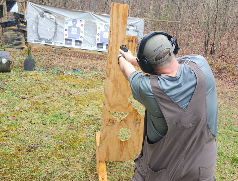 Man engaging targets from a barrier using self-defense firearm during training.