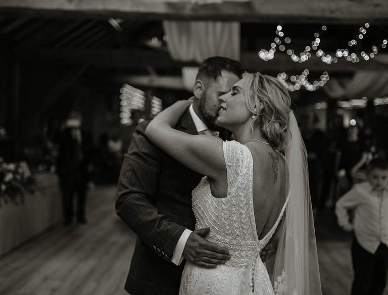 a bride and groom kissing in a barn wedding