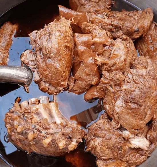 Carnitas de cerdo cocidas en su jugo en olla tradicional, preparadas por Carnitas y Barbacoa Nito en Querétaro