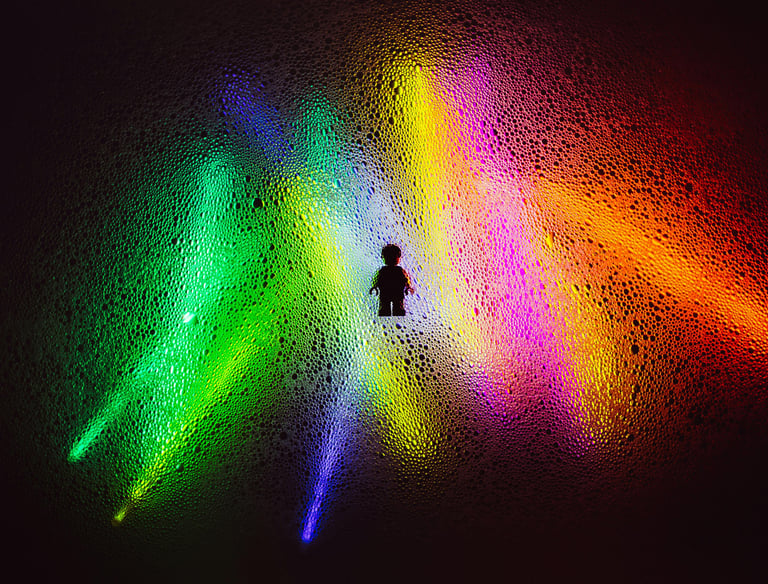 Contour van een persoon met kleurrijke lichtbundels, symboliseert botsende waarden en perspectieven.