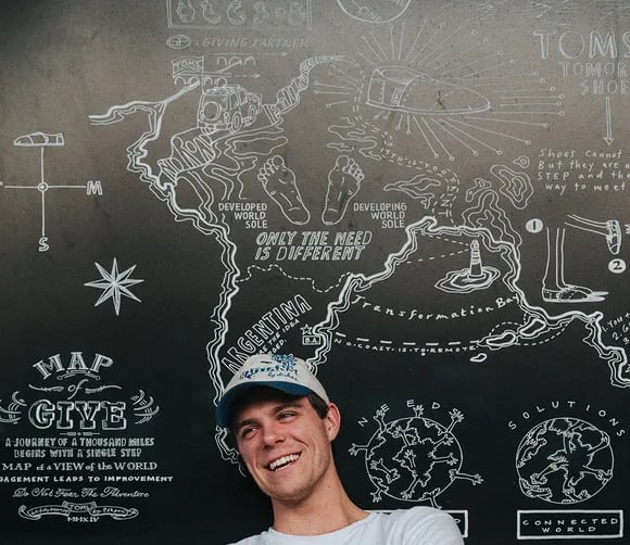 man in front of blackboard happy for receiving leadership coaching