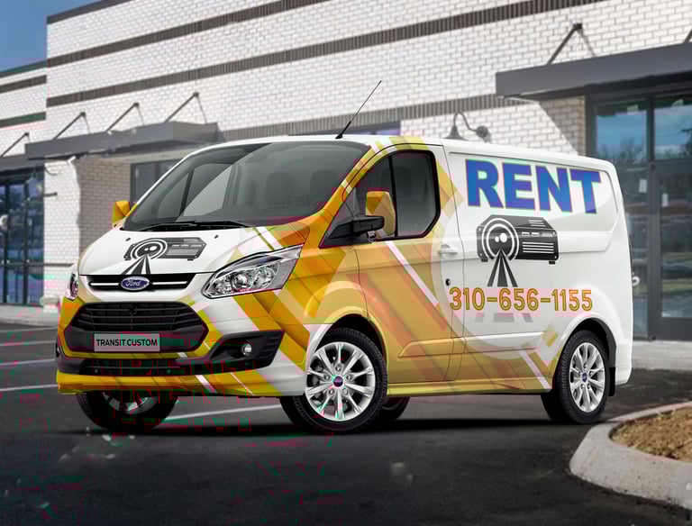 A colorful rental van with advertising graphics parked outside a building.