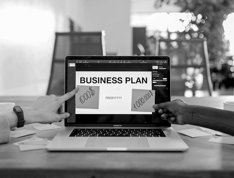 Un homme pointant un plan d'affaires sur un ordinateur portable