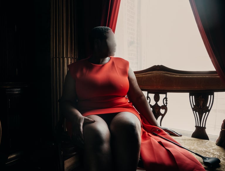 British escort sitting on a char, wearing an orange dress, Luxembourg