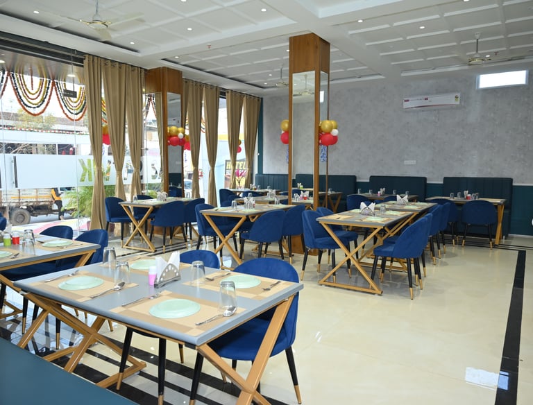 Modern restaurant dining room with blue chairs, wooden tables, and elegant interior decor.