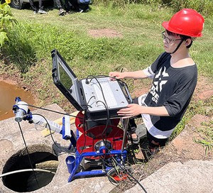 A technician using a robotic sewer camera system for pipeline inspection and maintenance.