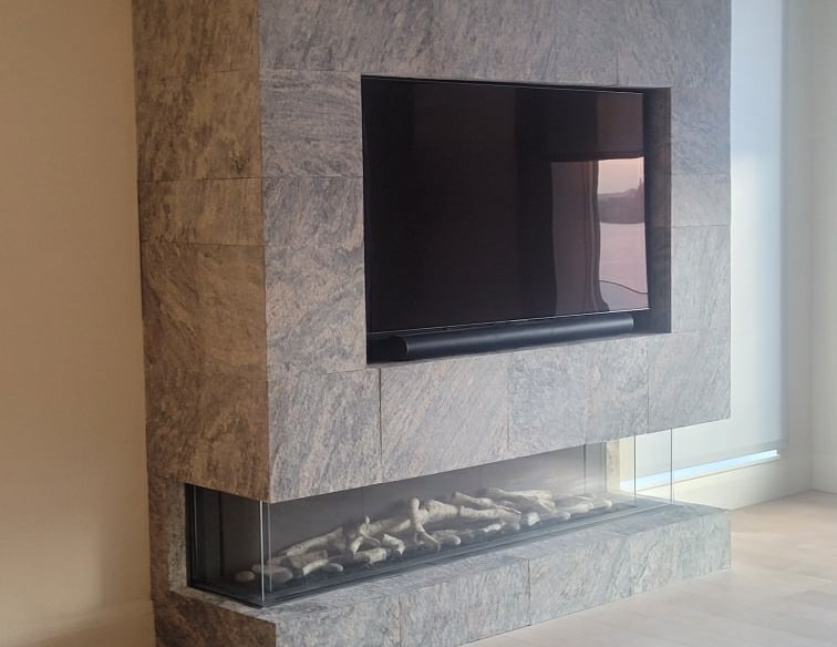 Modern granite stone fireplace with a recessed TV and sleek linear electric fireplace.