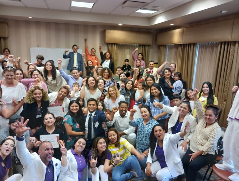 A diverse group of smiling professionals and families celebrating at a corporate graduation event.