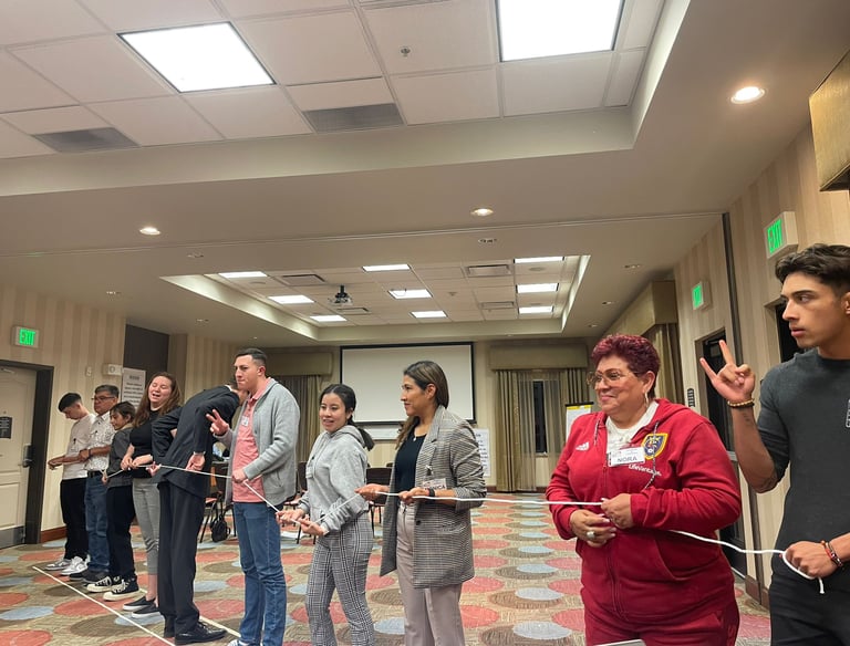 Diverse group of participants engaging in a team-building workshop activity with a white rope.
