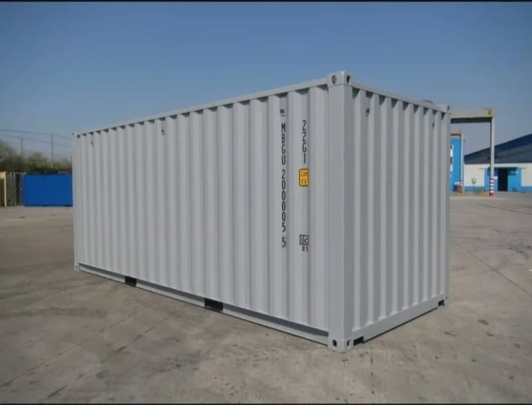 A light grey 20ft steel shipping container for storage and freight sitting on a concrete pad.