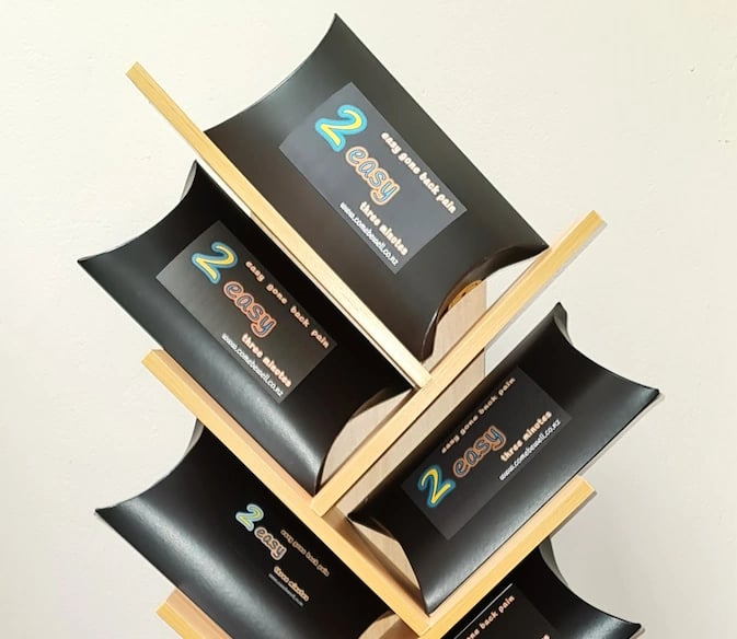 2 Easy’ back‑pain relief products arranged on a wooden display