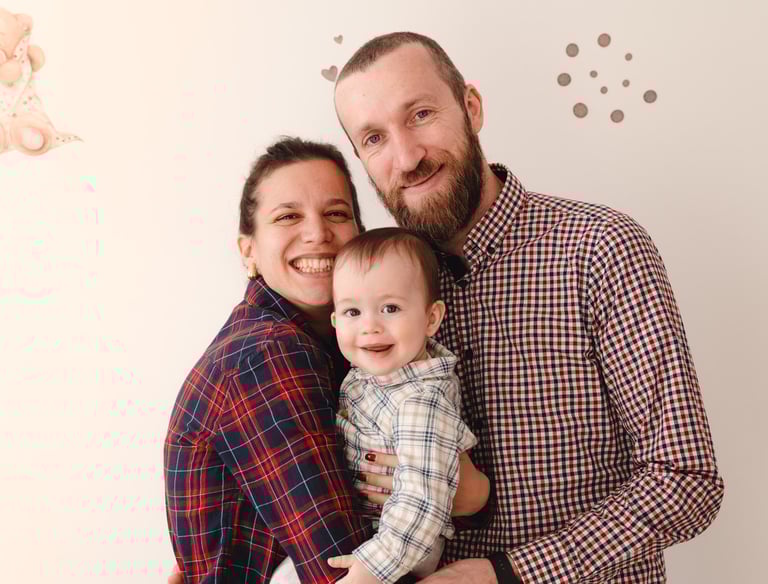 sretna obitelj koja drži svoju bebu