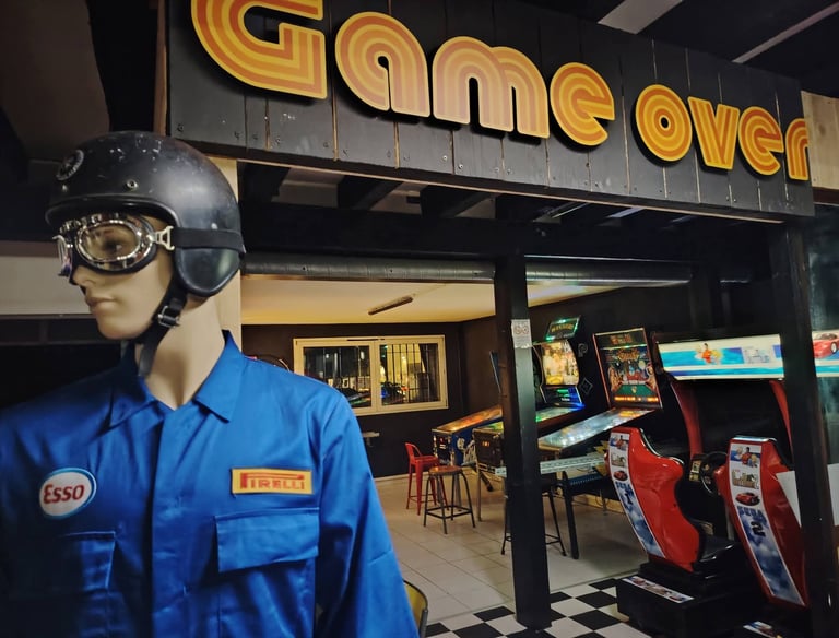 Vue d'ensemble de la salle de jeux avec bornes d'arcade rétro et flippers dans le décor industriel