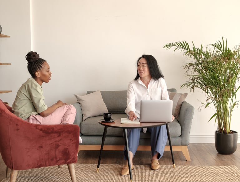 two women sitting on a couch in a living room